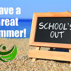 'School's out' written on a blackboard sitting on a beach