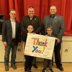 Students presenting community leaders with 'thank you' poster