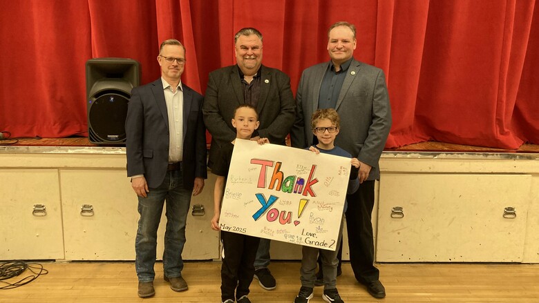 Students presenting community leaders with 'thank you' poster